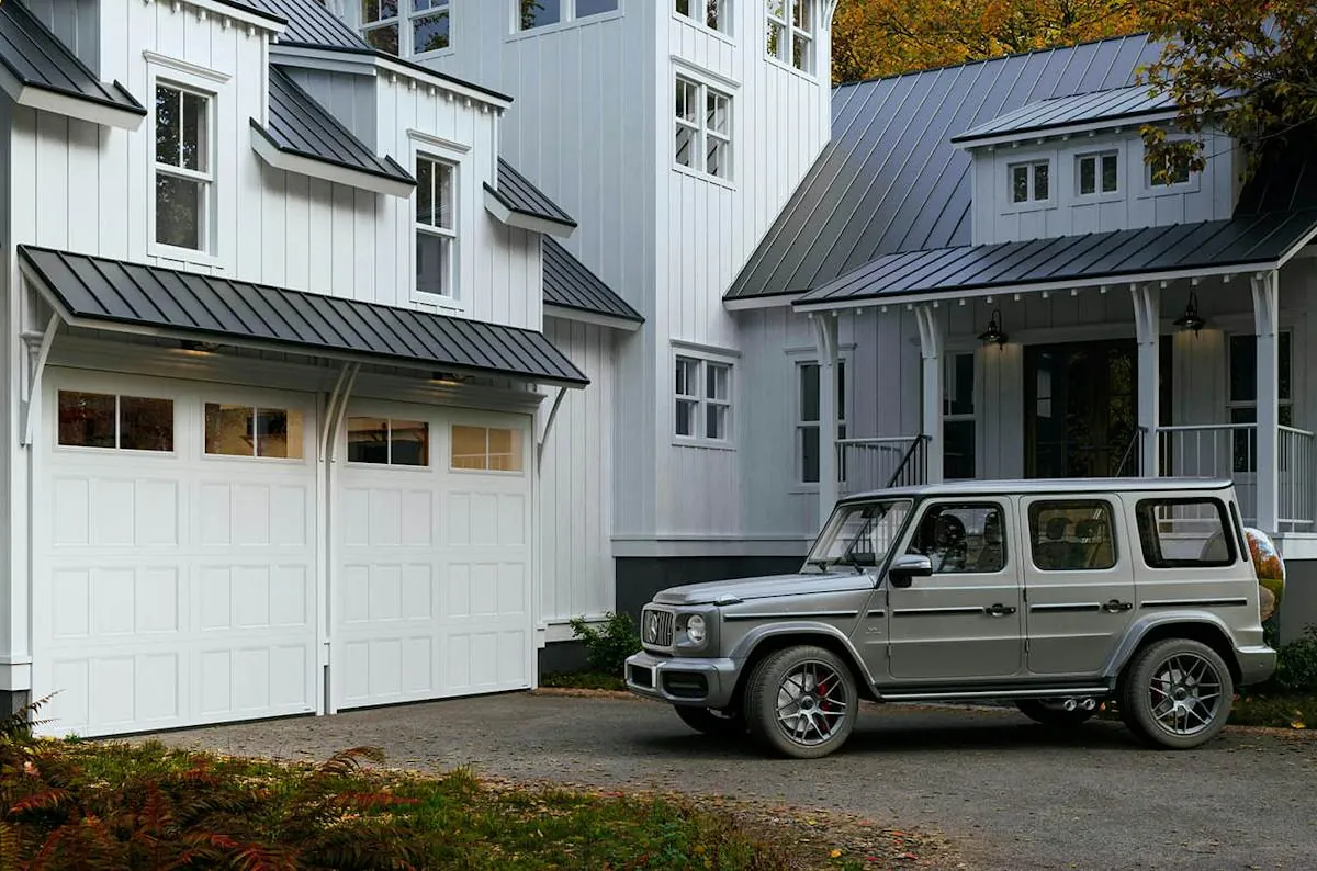 White farmhouse with two Hörmann Therma Style carriage house garage doors